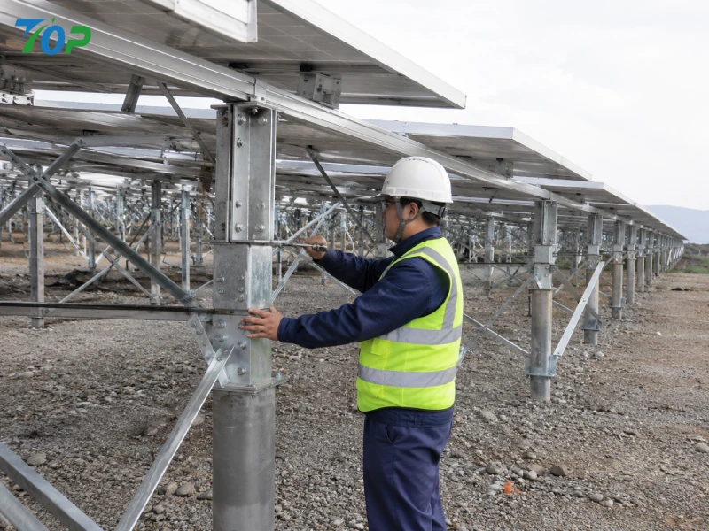 Engineer inspecting reinforced solar mounting structure with cross bracing in a high wind coastal project